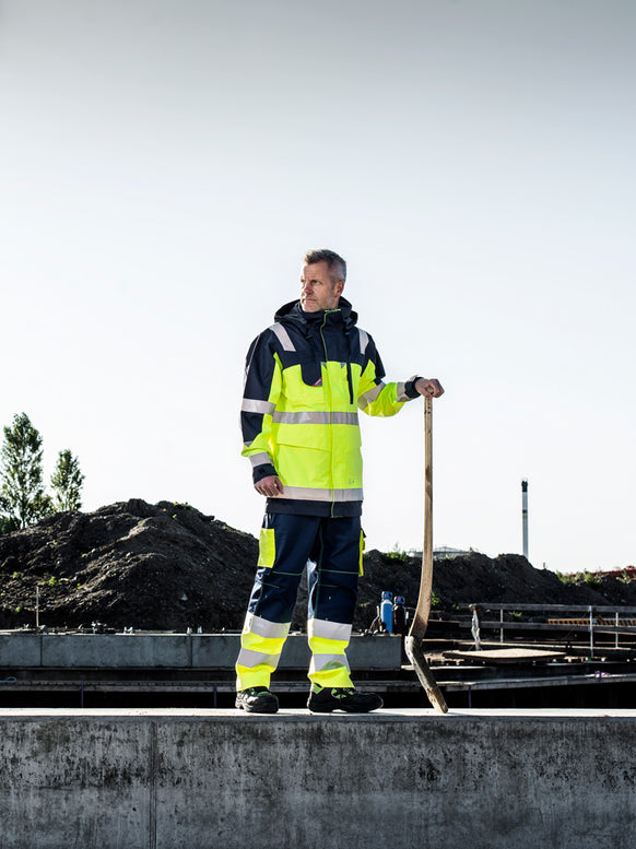 Mann mit personalisiertem Workwear, Arbeitskleidung bedrucken oder besticken Jacke